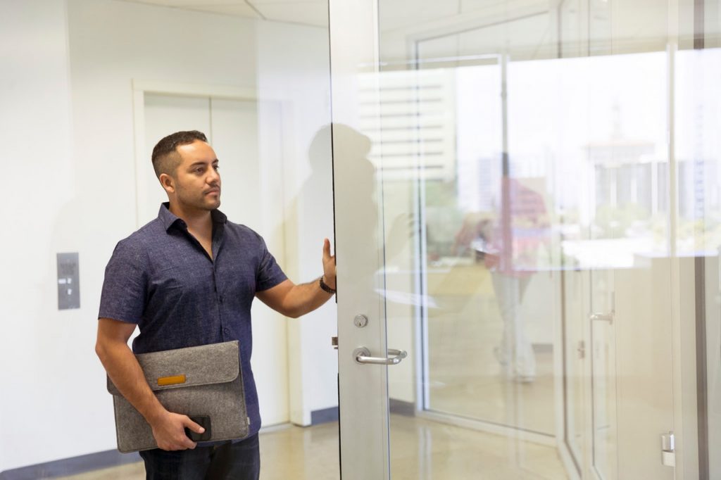 A man standing beside the office glass door